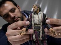 Volunteer Matteo Seia prepares a nativity figure for the 43rd edition of the "Presepio of Cavallermaggiore", a 300sqm Christmas Nativity crib in the Oratorio San Michele on December 20, 2019 in Cavallermaggiore, near Cuneo, Northwestern Italy. The "Presepio" is made by ten volunteers who every year spend 3 months to build a new edition with hundred of figures. MARCO BERTORELLO / AFP