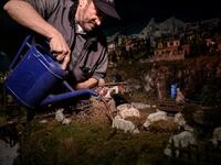 Volunteer Mario Curcetti uses a watering can to set a small river at the 43rd edition of the "Presepio of Cavallermaggiore", a 300sqm Christmas Nativity crib in the Oratorio San Michele on December 20, 2019 in Cavallermaggiore, near Cuneo, Northwestern Italy. The "Presepio" is made by ten volunteers who every year spend 3 months to build a new edition with hundreds of figures. MARCO BERTORELLO / AFP