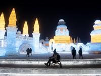 A tourist sits on an ice bike ahead of the opening of the Harbin International Ice and Snow Festival in Harbin, in China's northeast Heilongjiang province on January 3, 2020. NOEL CELIS / AFP