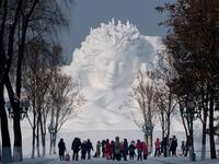 Tourists walk in front of an ice sculpture ahead of the opening of the Harbin International Ice and Snow Festival in Harbin, in China's northeast Heilongjiang province on January 4, 2020. NOEL CELIS / AFP