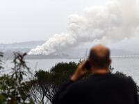 Smoke raises to the sky as a woodchip mill burns in Eden, in Australia's New South Wales state on January 6, 2020. January 5 brought milder conditions, including some rainfall in New South Wales and neighbouring Victoria state, but some communities were still under threat from out-of-control blazes, particularly in and around the town of Eden in New South Wales near the Victorian border. SAEED KHAN / AFP