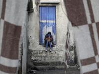 A Palestinian girl hugs her brother next to their family house during a cold weather spell in Gaza City's al-Shati camp on January 9, 2020. MOHAMMED ABED / AFP