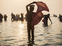A Hindu Sadhu (holy man) takes a holy dip in the Bay of Bengal during the Gangasagar Mela, at Sagar Island, some 150 kilometres south of Kolkata on January 14, 2020. XAVIER GALIANA / AFP