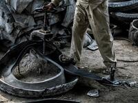 A labourer deconstructs a tyre at a rubber recycling workshop in the village of Mit al-Harun in Egypt's central Nile delta Gharbia Governorate, about 70 kilometres (43 miles) north of the capital, on January 14, 2020. Khaled DESOUKI / AFP