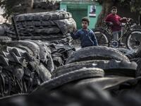 Children stand before piles of tyres at a rubber recycling workshop in the village of Mit al-Harun in Egypt's central Nile delta Gharbia Governorate, about 70 kilometres (43 miles) north of the capital, on January 14, 2020. Khaled DESOUKI / AFP