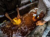 Workers dye yarns in a vat at a traditional hand-dying workshop in the Egyptian capital Cairo's centuries old district of Darb al-Ahmar on January 21, 2020. In Cairo's centuries-old Darb al-Ahmar district, Salama Mahmoud Salama's dye workshop is a multi-coloured den of textiles and busy workers colouring all kinds of fabrics. Khaled DESOUKI / AFP
