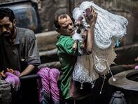 A worker carries undyed yarns to be processed at a traditional hand-dying workshop in the Egyptian capital Cairo's centuries old district of Darb al-Ahmar on January 21, 2020. Khaled DESOUKI / AFP
