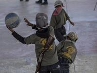 Children play basketball during a break as they are tought to use weapons by the Regional Coordinator of Community Authorities (CRAC-PF) community police force at a basketball court in the village of Ayahualtempan, Guerrero State, Mexico, on January 24, 2020. The CRAC-PF vigilante group trains children as young as five so they can protect themselves from drug-related criminal groups operating in the area. Pedro PARDO / AFP