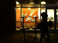 A person walks past a restaurant with "24" painted on the window as people mourn the death of NBA legend Kobe Bryant, who was killed along with his daughter and seven others in a helicopter crash on January 26, in Los Angeles on January 27, 2020. Federal investigators sifted through the wreckage of the helicopter crash that killed basketball legend Kobe Bryant and eight other people, hoping to find clues to what caused the accident that stunned the world. Frederic J. BROWN / AFP