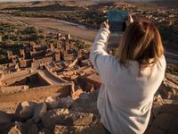 A tourist uses her phone to photograph the Kasbah (ancient fortress) of Ait-Ben-Haddou, where scenes depicting the fictional city of Yunkai from the hit HBO television series "Game of Thrones" were filmed, about 32 kilometres northwest of the city of Ouarzazate south of Morocco's High Atlas mountains on January 27, 2020.  FADEL SENNA / AFP