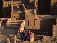 Men stand atop the Kasbah (ancient fortress) of Ait-Ben-Haddou, where scenes depicting the fictional city of Yunkai from the hit HBO television series "Game of Thrones" were filmed, about 32 kilometres northwest of the city of Ouarzazate south of Morocco's High Atlas mountains on January 27, 2020. FADEL SENNA / AFP