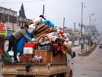 A Syrian youth climbs atop belongings in the back of a truck as people leave the town of Binnish in the northwestern province of Idlib, on February 4, 2020, amid an ongoing offensive by pro-regime forces. A Russian-backed Syrian government offensive against the country's last rebel enclave of Idlib has displaced more than half a million people in two months, according to the United Nations. The wave of displacement, which coincides with a biting winter, is one of the largest since the start of the Syrian wa