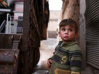A Syrian child looks up as relatives load belongings onto a truck ahead of leaving the town of Binnish in the northwestern province of Idlib, on February 4, 2020, amid an ongoing offensive by pro-regime forces. A Russian-backed Syrian government offensive against the country's last rebel enclave of Idlib has displaced more than half a million people in two months, according to the United Nations. The wave of displacement, which coincides with a biting winter, is one of the largest since the start of the Syr