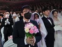 A couple wearing protective face masks attend a mass wedding ceremony organised by the Unification Church at Cheongshim Peace World Center in Gapyeong on February 7, 2020. South Korea has confirmed 24 cases of the SARS-like virus so far and placed nearly 260 people in quarantine for detailed checks amid growing public alarm. Jung Yeon-je / AFP