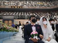 Couples wearing protective face masks attend a mass wedding ceremony organised by the Unification Church at Cheongshim Peace World Center in Gapyeong on February 7, 2020. South Korea has confirmed 24 cases of the SARS-like virus so far and placed nearly 260 people in quarantine for detailed checks amid growing public alarm. Jung Yeon-je / AFP