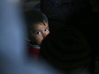 A child looks on as he sits with other members of a family of internally displaced Syrians in an underground shelter where several families from Aleppo and Idlib provinces are taking refuge, in the village of Taltunah about 15 kilometres northwest of Idlib in the northwestern Idlib province, on February 23, 2020. Aref TAMMAWI / AFP