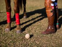 In this photograph taken on January 11, 2020, Linthoingambi Kangjei Lup Polo Club player Shanglenmayum Sangeeta stands next to her Manipuri pony as she adjusts the length of the stirrups leather before the start of their 15th Women's State Polo Tournament match at the Mapal Kangjeibung (Polo Ground) in Imphal, the capital of the northeastern Indian state of Manipur. Laishram Thadoi's face is a picture of concentration as she adjusts her helmet and prepares to play in Manipur, the remote Indian state regarde