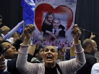 A Likud party supporter holds up a poster showing Israeli Prime Minister Benjamin Netanyahu embraced by his wife Sara with a heart behind them as she chants slogans at the Likud's electoral headquarters in the coastal city of Tel Aviv on March 2, 2020, after polls officially closed. Netanyahu claimed "a giant victory" in elections on March 3, boasting that his right-wing Likud party had defied "all expectations" in the country's third vote in less than a year. After exit polls by three networks forecast tha