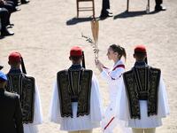 Torchbearer Greece's Anna Korakaki, Rio 2016 gold medallist in the 25m pistol shooting, walks past Greek Evzones Guard as she holds the Olympic flame and an olive branch during the flame lighting ceremony on March 12, 2020 in ancient Olympia, ahead of the Tokyo 2020 Olympic Games. ARIS MESSINIS / AFP