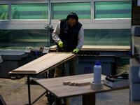 An employee works at the Eurocoffin coffins factory in Barcelona on April 3, 2020. More than 900 people died in Spain over the past 24 hours for the second day running, government figures showed, although the rate of new infections and deaths continued to slow. Spain has the world's second-highest death toll after Italy with the virus so far claiming 10,935 lives from 117,710 confirmed cases.  PAU BARRENA / AFP