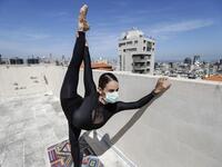 Sherazade Mami, a 28-year-old Tunisian professional dancer and performer at the Caracalla dance theatre and a teacher at the Caracalla dance school, practices while wearing a surgical mask on the roof of her apartment building in the suburb of Dekwaneh on the eastern outskirts of Lebanon's capital Beirut on April 4, 2020. Due to the confinement regulations imposed to combat the COVID-19 coronavirus pandemic, Mami opted to continue practicing on her rooftop to remain in shape. JOSEPH EID / AFP
