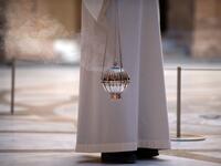 A priest holds an incense burner during the Palm Sunday Mass on April 5, 2020, at the Santa Maria de Montserrat abbey in Monistrol de Montserrat, during a national lockdown to prevent the spread of the COVID-19 disease. Spain saw its third consecutive daily decline in the number of people dying from the coronavirus pandemic as the country recorded another 674 fatalities today. Josep LAGO / AFP
