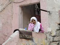 A Lebanese woman sits at her home's entrance during confinement due to the COVID-19 pandemic, in the historic part of the southern coastal city of Sidon (Saida), on April 6, 2020. Lebanon's President called on international donors to provide financial assistance to the crisis-hit country as it grapples with a severe economic downturn compounded by the novel coronavirus pandemic. JOSEPH EID / AFP