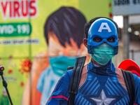 An Indonesian police officer wearing a superhero costume on the street disinfects motorists' vehicles in Pasuruan, East Java on April 9, 2020, amid concert to the COVID-19 coronavirus. JUNI KRISWANTO / AFP