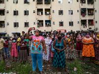 Residents watch a music band formed by Sri Lankan Navy personnel as they play outside a housing complex during a government-imposed nationwide lockdown as a preventive measure against the COVID-19 coronavirus, in Colombo on April 9, 2020. ISHARA S. KODIKARA / AFP