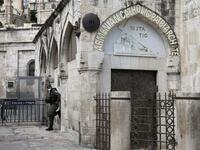 An Israeli border policeman wearing a protective mask stands guard by the third station of the Way of the Cross, also known as the Via Dolorosa, believed to be the route Jesus walked carrying the cross on the way to crucifixion, in Jerusalem's Old City, on April 7, 2020. All cultural sites in the Holy Land are shuttered, regardless of their religious affiliation, as authorities seek to forestall the spread of the deadly respiratory disease, which will prevent Christians from congregating for the Easter serv