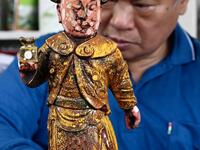 In this picture taken on March 17, 2020, sculptor Lin Hsin-lai restores a Taoist god statue at his workplace in Taoyuan, northern Taiwan on March 17, 2020. Every spare surface of Lin Hsin-lai's four-storey shop is crammed with a pantheon of Taiwan's celestial beings, testament to the decades he has spent sheltering and restoring unwanted statues of gods.  Sam Yeh / AFP
