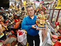 In this picture taken on March 17, 2020, sculptor Lin Hsin-lai displays a Taoist god statue at his workplace in Taoyuan, northern Taiwan. Every spare surface of Lin Hsin-lai's four-storey shop is crammed with a pantheon of Taiwan's celestial beings, testament to the decades he has spent sheltering and restoring unwanted statues of gods.  Sam Yeh / AFP