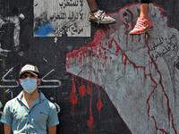 An Iraqi protester, wearing a protective mask, is pictured on the Al-Jumhuriyah bridge in the capital Baghdad on May 11, 2020, during an anti-government demonstration. AHMAD AL-RUBAYE / AFP