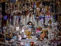 A seller of religious figurines poses at her stall wearing a face mask during the 103rd anniversary of the apparitions of Our Lady of Fatima at the Fatima shrine in central Portugal on May 13, 2020. Without the crowd of pilgrims it welcomes every year, the shrine of Fatima celebrated the anniversary during a religious ceremony reduced to the bare minimum. PATRICIA DE MELO MOREIRA / AFP