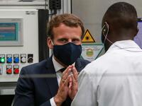 French President Emmanuel Macron, wearing a face mask, speaks to a worker as he visits the factory of manufacturer Valeo in Etaples, near Le Touquet, northern France on May 26, 2020 as part of the launch of a plan to rescue the French car industry. Ludovic MARIN / POOL / AFP