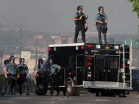 Police stand watch near a protest May 28, 2020 in St. Paul, Minnesota. Today marks the third day of ongoing protests after the police killing of George Floyd. Four Minneapolis police officers have been fired after a video taken by a bystander was posted on social media showing Floyd's neck being pinned to the ground by an officer as he repeatedly said, "I cant breathe." SCOTT OLSON / GETTY IMAGES NORTH AMERICA / Getty Images via AFP