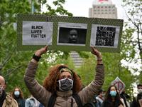 A woman is holding a Black Lives Matter placard asking for Justice for George and other victims of racism and police brutalities on Montreal's Place du Canada on May 31, 2020. Several thousands demonstrators marched on Sunday in central Montreal against racism and police violence, in solidarity with demonstrations in the United States following the death of George Floyd. Eric THOMAS / AFP