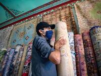 A Moroccan rug dealer lines up carpets at a shop in the city of Sale, north of the capital Rabat, on June 3, 2020, during the novel coronavirus pandemic. Artisans in Morocco have been starved of income for almost three months because of the COVID-19 pandemic. The crafts industry represents some seven percent of GDP, with an export turnover last year of nearly 1 billion dirhams ($100 million). FADEL SENNA / AFP