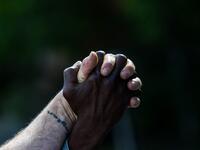 Micheal Jones (R) holds hands with Tim Higgins (L) as they protest on the fourth day on the fourth day following Rayshard Brooks' shooting death by police in a Wendy's restaurant parking lot, June 16, 2020, in Atlanta, Georgia. The fatal shooting of Brooks, a black man, by a white police officer in Atlanta has poured more fuel on the raging US debate over racism, prompting another round of street protests and the resignation of the southern city's police chief. The death of 27-year-old Rayshard Brooks was r