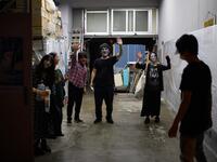 This picture taken on June 15, 2020 shows drive-in haunted house actors (L to R) Haruna Suzuki, 20, Asami Takeuchi, 33, Kota Hanegawa, 28, Kenta Iwana, 25, Ayaka Imaide, 34, and sound and lights engineer Daichi Ono waing to AFP reporters after a demonstration of a drive-in haunted house at a garage in Tokyo. A car horn beeps and the horror begins: a bloody murder and rampaging zombies.Philip FONG / AFP