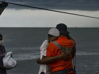 A Rohingya man from Myanmar hugs an Indonesian officer after being evacuated from a boat onto the shorelines of Lancok village, in Indonesia's North Aceh Regency on June 25, 2020. Nearly 100 Rohingya from Myanmar, including 30 children, have been rescued from a rickety wooden boat off the coast of Indonesia's Sumatra island, a maritime official said. CHAIDEER MAHYUDDIN / AFP