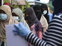 Rohingya woman from Myanmar queue up as they go through identification procedures by Indonesian police at the immigration detention centre in Lhokseumawe in Indonesia's North Aceh Regency on June 26, 2020. Nearly 100 Rohingya asylum seekers stranded off the coast of Indonesia were pulled to shore on June 25 by locals angered at the refusal of authorities to give them shelter over coronavirus fears. CHAIDEER MAHYUDDIN / AFP