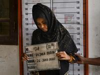 A Rohingya woman from Myanmar goes through an identification procedure by Indonesian police at the immigration detention centre in Lhokseumawe in Indonesia's North Aceh Regency on June 26, 2020. Nearly 100 Rohingya asylum seekers stranded off the coast of Indonesia were pulled to shore on June 25 by locals angered at the refusal of authorities to give them shelter over coronavirus fears. CHAIDEER MAHYUDDIN / AFP