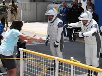 NASA astronauts Bob Behnken (R) and Doug Hurley say goodbye to family members after walk ing out of the Operations and Checkout Building on their way to the SpaceX Falcon 9 rocket with the Crew Dragon spacecraft on launch pad 39A at the Kennedy Space Center on May 30, 2020 in Cape Canaveral, Florida. The inaugural flight will be the first manned mission since the end of the Space Shuttle program in 2011 to be launched into space from the United States. Joe Raedle/Getty Images/AFP