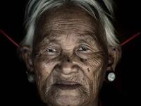 A woman from the Konyak tribe wears plugs in her both her lobes while another set, believed to be made from bone, protrude at jagged angles from the top of her ears. (Mediadrumimages/ Trevor Cole)