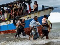 Acehnesse fishermen help evacuate Rohingya children from Myanmar onto the shorelines of Lancok village, in Indonesia's North Aceh Regency on June 25, 2020. - Nearly 100 Rohingya from Myanmar, including 30 children, have been rescued from a rickety wooden boat off the coast of Indonesia's Sumatra island, a maritime official said. (Photo by CHAIDEER MAHYUDDIN / AFP)