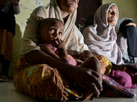 Rohingya people from Myanmar wait for aid at the immigration detention centre in Lhokseumawe in Indonesia's North Aceh Regency on June 26, 2020. Nearly 100 Rohingya asylum seekers stranded off the coast of Indonesia were pulled to shore on June 25 by locals angered at the refusal of authorities to give them shelter over coronavirus fears. CHAIDEER MAHYUDDIN / AFP