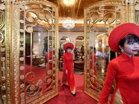 Staff wait to welcome guests in the lobby of the newly-inaugurated Dolce Hanoi Golden Lake hotel, the world's first gold-plated hotel, in Hanoi on July 2, 2020. Manan VATSYAYANA / AFP