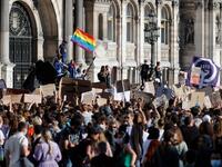 A protester (L) waves a rainbow flag, symbol of LGBTQ social movements, and others hold placards during a demonstration called by feminist movements in front of the city hall in Paris, on July 10, 2020, to denounce the nomination of French Interior Minister, facing rape accusations and French Justice Minister who criticised the #MeToo movement against sexual harassment. Thomas COEX / AFP