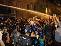 Journalists film as Israeli police spray protesters (clad in masks due to the COVID-19 coronavirus pandemic) with water cannon during an anti-government demonstration in Jerusalem, on July 18, 2020. Ahmad GHARABLI / AFP